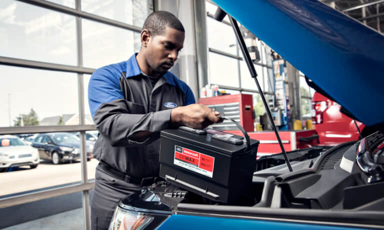 Ford technician replacing a car's battery